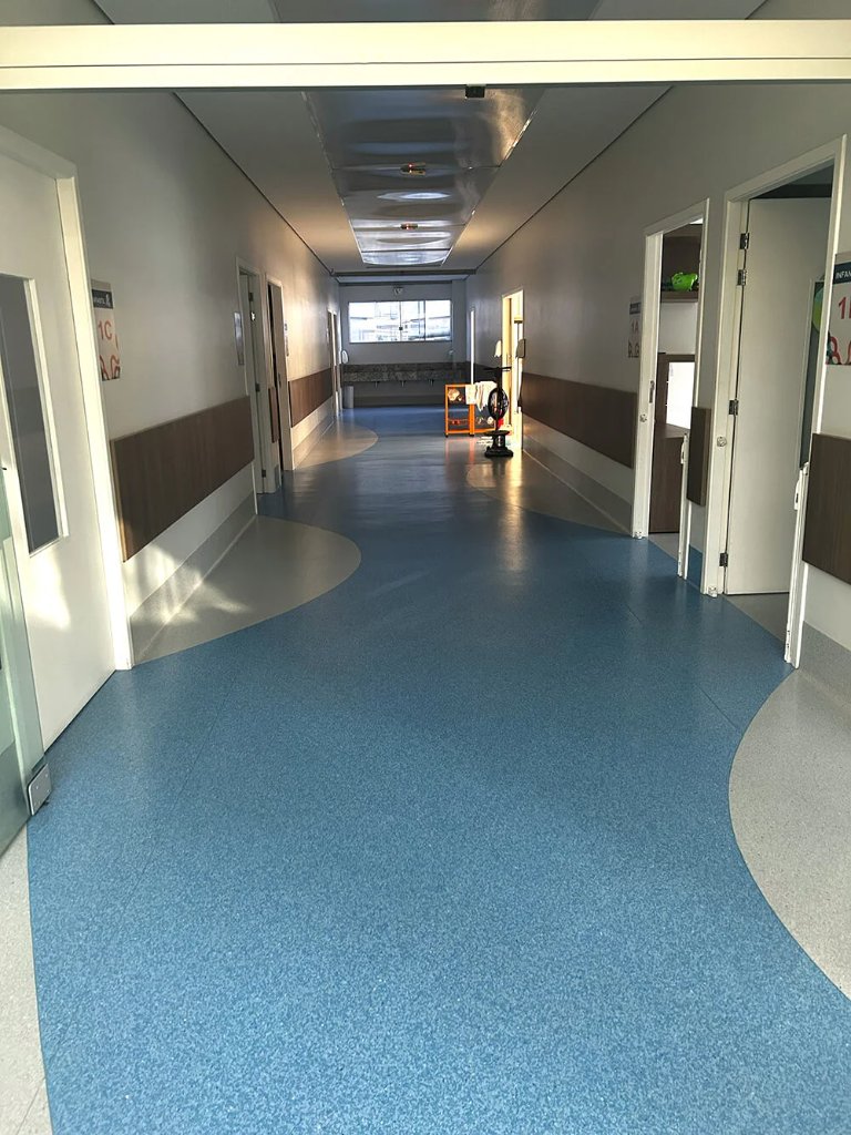 Corredor hospitalar com piso azul